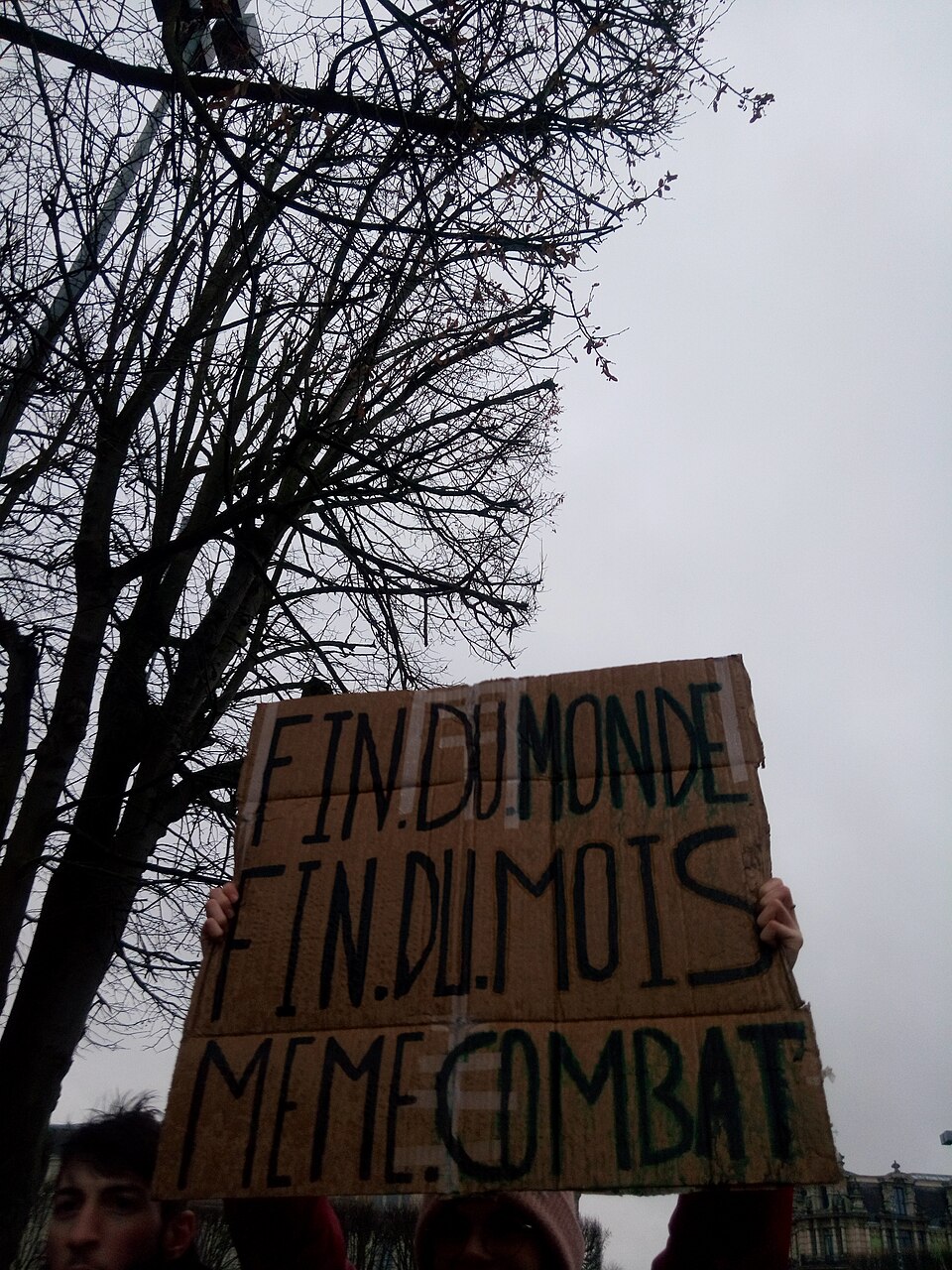 Banderole peinte « Fin du monde et fin du mois, même combat » portée dans un cortège à Lille.