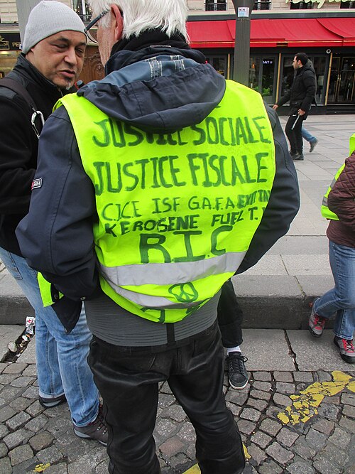 Gilets annotés au feutre « Justice sociale, justice fiscale » et « RIC ».