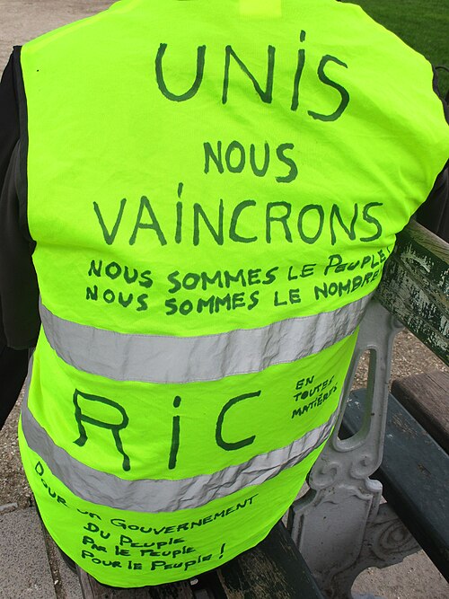 Dos d'un gilet annoté « Unis nous vaincrons, nous sommes le peuple » et « RIC ».